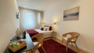 um quarto de hotel com uma cama, uma mesa e cadeiras em MyTrip Porto em Matosinhos