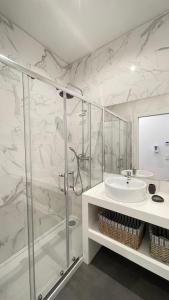 a white bathroom with a shower and a sink at MyTrip Porto in Matosinhos