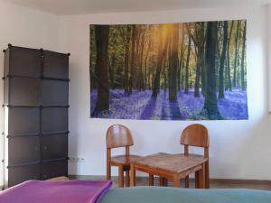 1 dormitorio con mesa, 2 sillas y una pintura en Gesundheits- und Wohlfühlzentrum Matz, en Sulzdorf an der Lederhecke