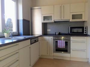 a kitchen with white cabinets and a stove top oven at Gesundheits- und Wohlfühlzentrum Matz in Sulzdorf an der Lederhecke