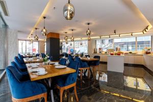 a restaurant with blue chairs and tables and a kitchen at Urban Hotel Bomonti in Istanbul