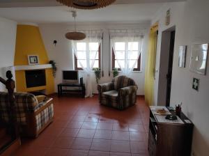 a living room with two chairs and a television at Al Casa Paquito in Almograve