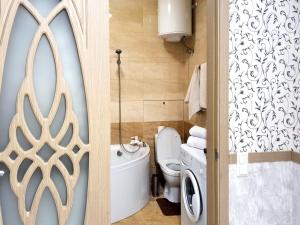 a bathroom with a toilet and a washing machine at Lux Apartament Dacha in Kharkiv