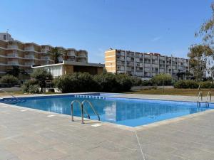 a swimming pool in front of a large building at Bertoni by the Sea in La Pineda