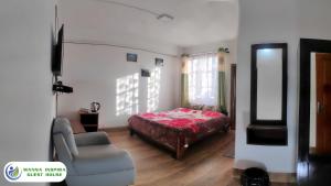 a bedroom with a bed and a couch and a chair at MANNA INSPIRA in Shillong