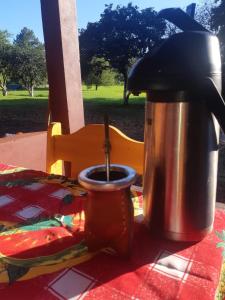 a coffee pot and a cup on a table at Cabañas El Despertar in Puerto Iguazú