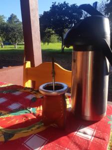 a coffee pot and a cup on a table at Cabañas El Despertar in Puerto Iguazú +12 photos