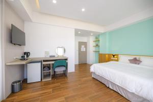 ein Hotelzimmer mit einem großen Bett und einem Schreibtisch in der Unterkunft 龍弘民宿星漾館 in Magong