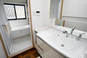 a white bathroom with a sink and a mirror at Gairoju / Vacation STAY 2561 in Higashi-osaka