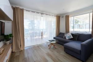 Manly Beachfront Apartment في سيدني: غرفة معيشة مع أريكة ونافذة كبيرة