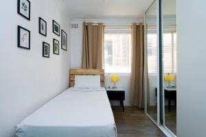 - une chambre avec un lit et un miroir dans l'établissement Manly Beachfront Apartment, à Sydney