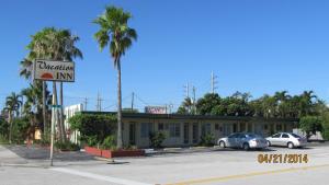 a building with cars parked in a parking lot at Vacation Inn Motel in Fort Lauderdale