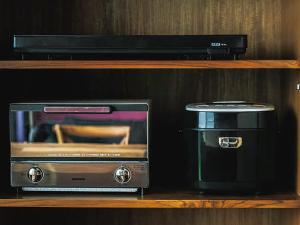 a microwave and a toaster oven sitting on a shelf at CHULAX OKINAWA YOMITAN【Designer Condominium Hotel】 in Yomitan