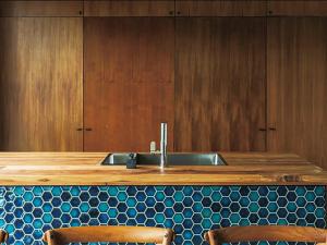 a kitchen with a sink and some wooden cabinets at CHULAX OKINAWA YOMITAN【Designer Condominium Hotel】 in Yomitan