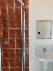 a bathroom with a shower, sink, and mirror at Beaconsfield Lodge Motel in Beaconsfield