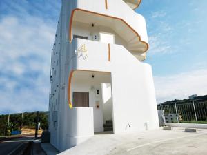 un edificio blanco con una escalera de caracol en CHULAX OKINAWA YOMITAN【Designer Condominium Hotel】, en Yomitan