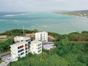 an aerial view of two white buildings and the ocean at CHULAX OKINAWA YOMITAN【Designer Condominium Hotel】 in Yomitan