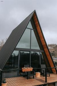 a large glass house with a table on a deck at Hilltop Batumi in Batumi