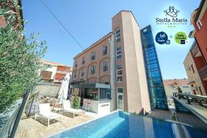 un hotel con piscina frente a un edificio en Hotel Stella Maris en Vodice