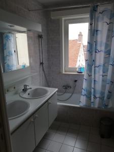 een badkamer met 2 wastafels en een douchegordijn bij Virginie 2 in Koksijde