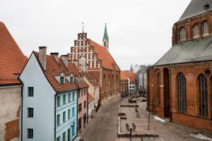an old city street with buildings and a church at Redstone Apartments in Riga