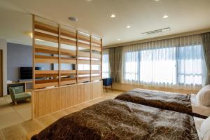 a hotel room with two beds and a television at 田沢湖水沢温泉郷セルリアンリゾートAoni in Senboku