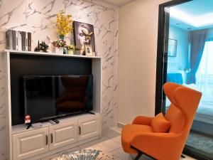 依斯干達公主城的住宿－Stay @ Almas Puteri Harbour，客厅配有橙色椅子和电视