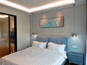 una camera con un grande letto con testiera blu di Stay @ Almas Puteri Harbour a Nusajaya
