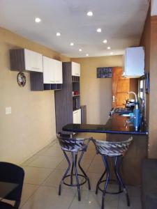 阿蒂加斯的住宿－N1 1 Apartamento Completo 2 Dormitorios en Centro de Artigas，厨房配有桌子和2把酒吧凳