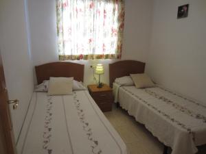 two beds in a small room with a window at Apartamentos Marina Park in Oropesa del Mar