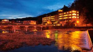 a building on a bridge over a river at night at Mansuirou in Misasa