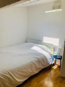 a white bed in a room with a blue table at Duplex La Ciotat - superbe 85 m2 - 6 pers - 3 chambres - Climatisation - Vue mer et proche du vieux port La Ciotat in La Ciotat