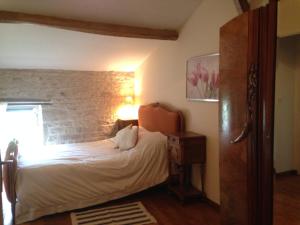 ein Schlafzimmer mit einem Bett und einer Ziegelwand in der Unterkunft Columba - Les Constellations in Doeuil-sur-le-Mignon