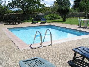 a swimming pool with two chairs and a table at Columba - Les Constellations in Doeuil-sur-le-Mignon