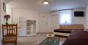 uma sala de estar com um sofá e um frigorífico em Silentium Garden Apartman Sárvár em Sárvár