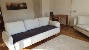 a living room with a white couch and a table at HAUS WALD und SEE - WASSERBURG in Wasserburg am Bodensee +5 photos
