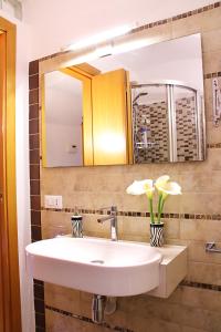 lavabo con espejo y jarrón con flores en La casetta del cuore, en Monopoli 27 fotos más