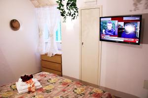 Un dormitorio con una cama con un televisor en la pared. en La casetta del cuore, en Monopoli