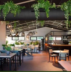 een restaurant met tafels, stoelen en planten bij Chalet Zonnig Zeeland in Oostkapelle
