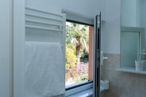 a bathroom with a shower curtain and a window at Rex Hotel Residence in Genoa