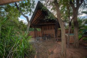 a pavilion with chairs and tables in a garden at NJIRI LODGE - Your part of Africa in Marloth Park
