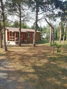 une maison avec un groupe d'arbres devant elle dans l'établissement Au Soleil de Picardie, à Presles-et-Boves