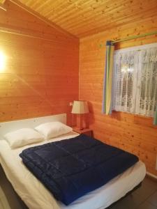 um quarto com uma cama com um cobertor azul em Au Soleil de Picardie em Presles-et-Boves