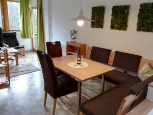 salon z drewnianym stołem i krzesłami w obiekcie Ferienwohnungen Vidoni w mieście Bodensdorf