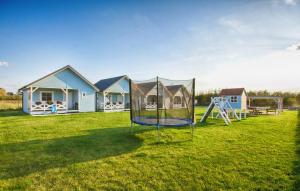 a house with a playground in the yard at Domki PoZdrowie in Rusinowo