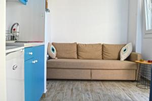 a living room with a couch in a kitchen at Syrona in Posidhonía
