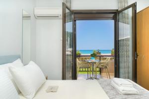 a bedroom with a bed and a view of the ocean at Kamelia & Semeli Hotel in Skala Potamias