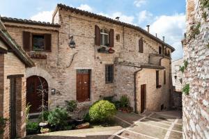 een oud stenen huis met een binnenplaats in een stad bij Casa Clara Appartamenti - Dimora Superior in Assisi
