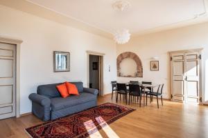 een woonkamer met een blauwe bank en een tafel bij Casa Clara Appartamenti - Dimora Superior in Assisi