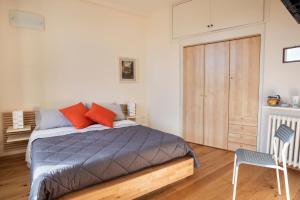 een slaapkamer met een bed met rode kussens en een stoel bij Casa Clara Appartamenti - Dimora Superior in Assisi